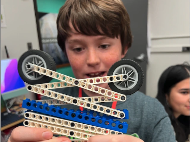 A boy shows off his lego creation